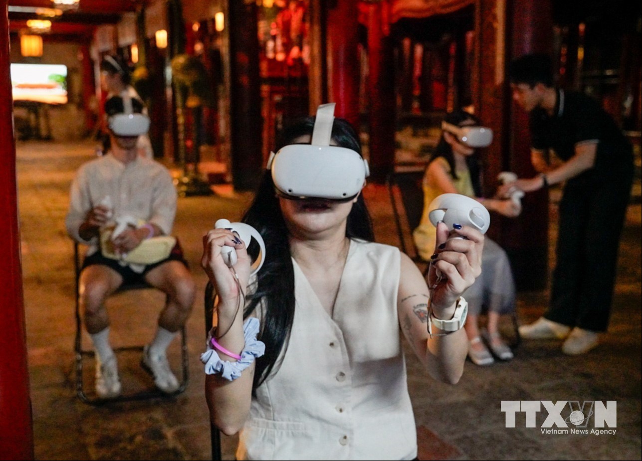 Du khách trải nghiệm công nghệ thực tế ảo tại tour đêm Văn Miếu. (Ảnh: Khánh Hoà/TTXVN)